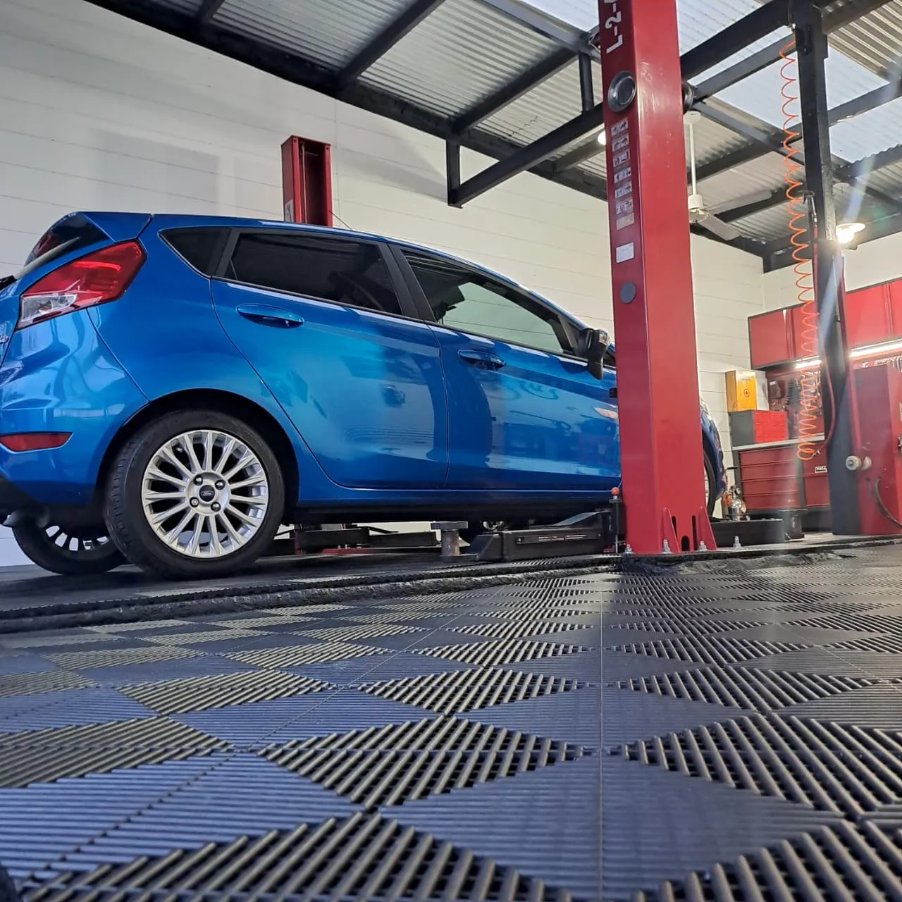 Auto sobre piso rejilla NEXA en taller